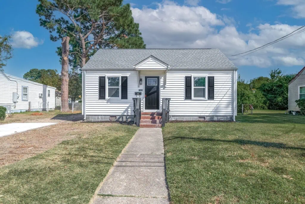 A house with a pathway and grass lawn