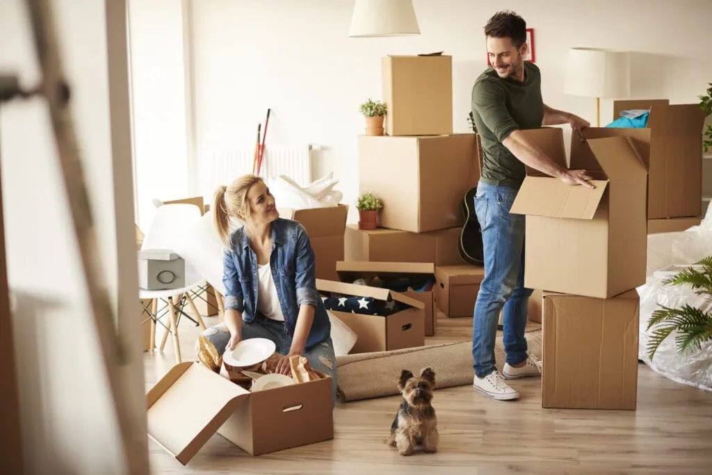 A man and woman packing boxes to move houses due to a job relocation