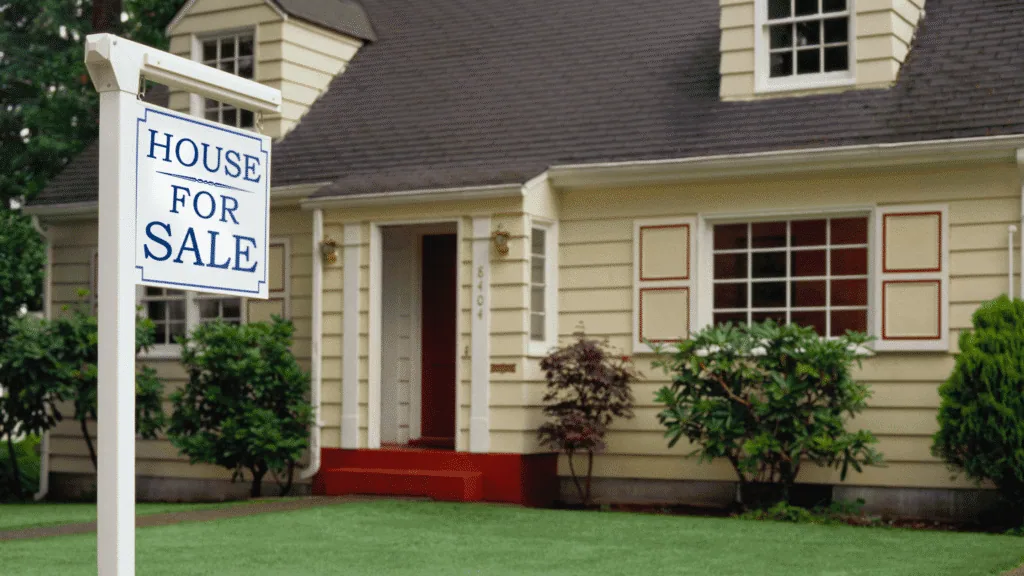 A house with a House For Sale sign in front of it
