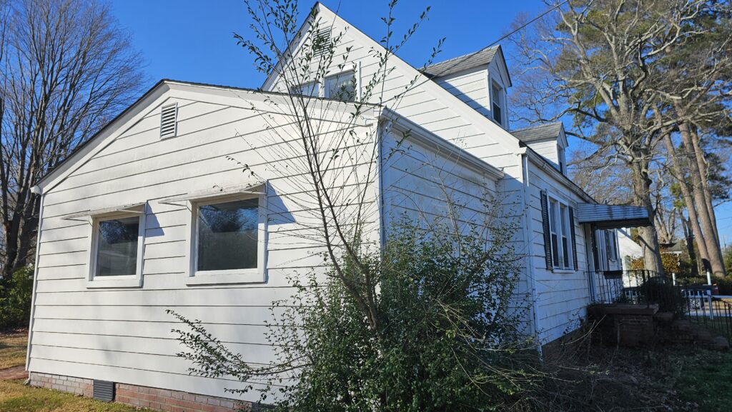 The side of a house with an overgrown push in Surry, Virginia